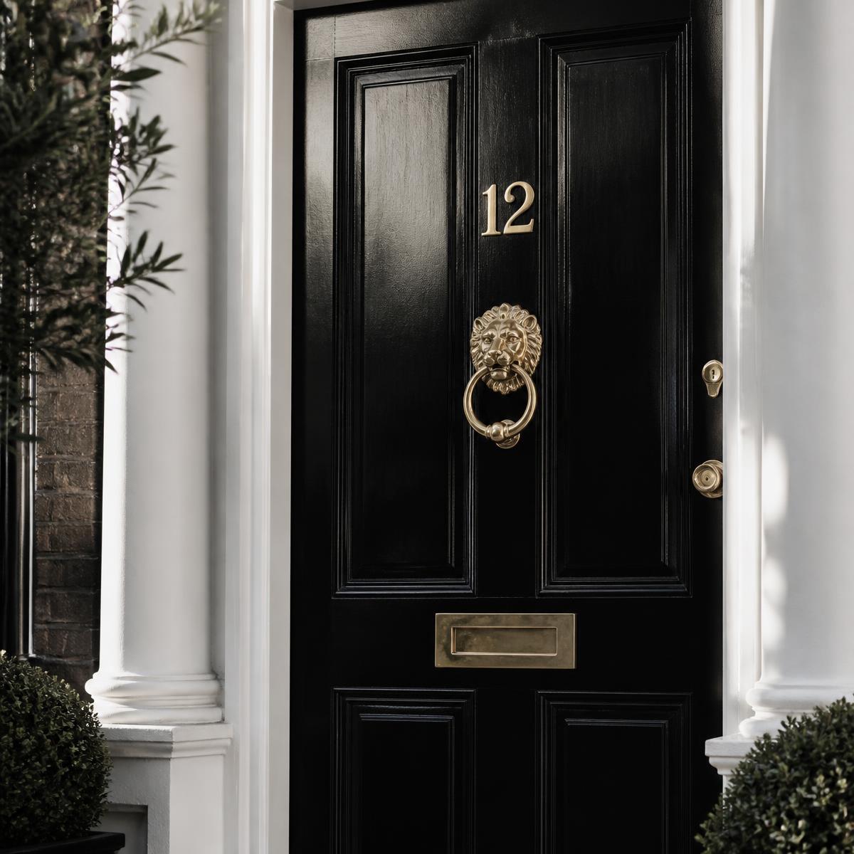 A glossy black London front door with brass numerals